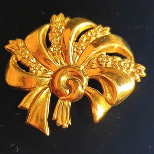 Vintage brooch. It appears to be tin with a gold coating no markings.
